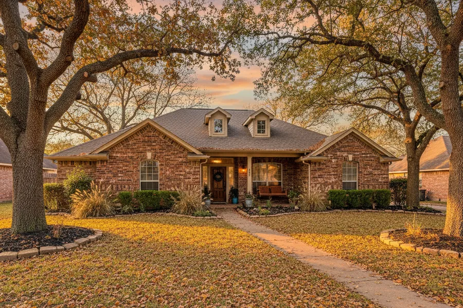 A residential front yard in Texas covered in fallen autumn leaves before a seasonal cleanup